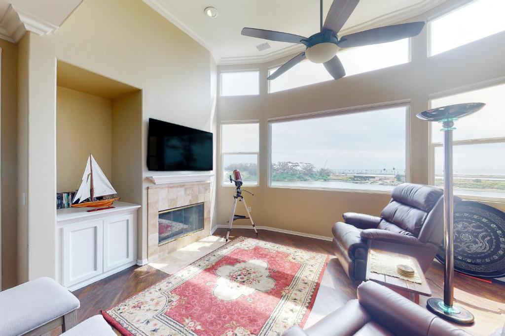 a living room with a ceiling fan and a fireplace at Lagoon Sunrise 205 in Carlsbad