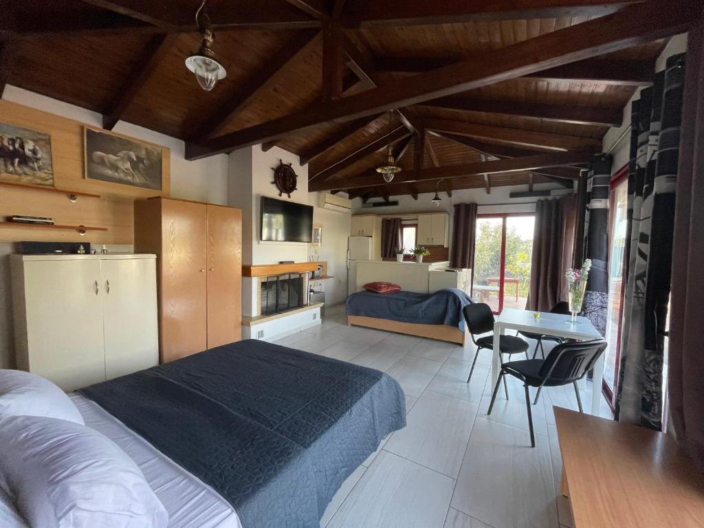 a bedroom with a bed and a kitchen and a table at Country Lux Apartment near Airport in Markopoulo