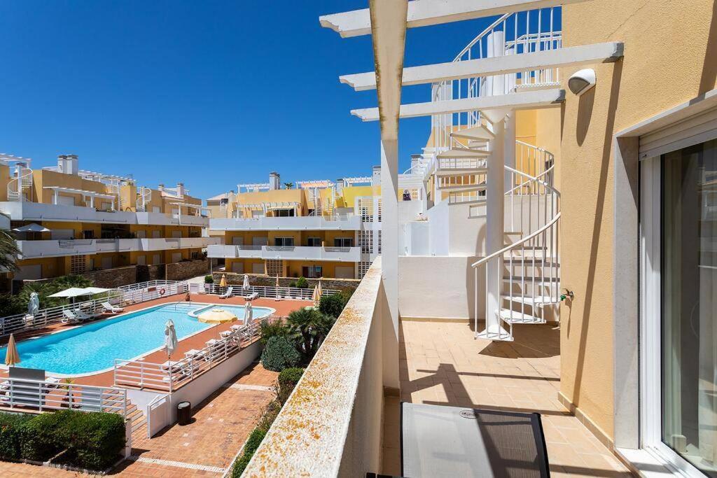 vistas a la piscina desde el balcón de un edificio en Royal Cabanas Gold penthouseT2 en Conceição