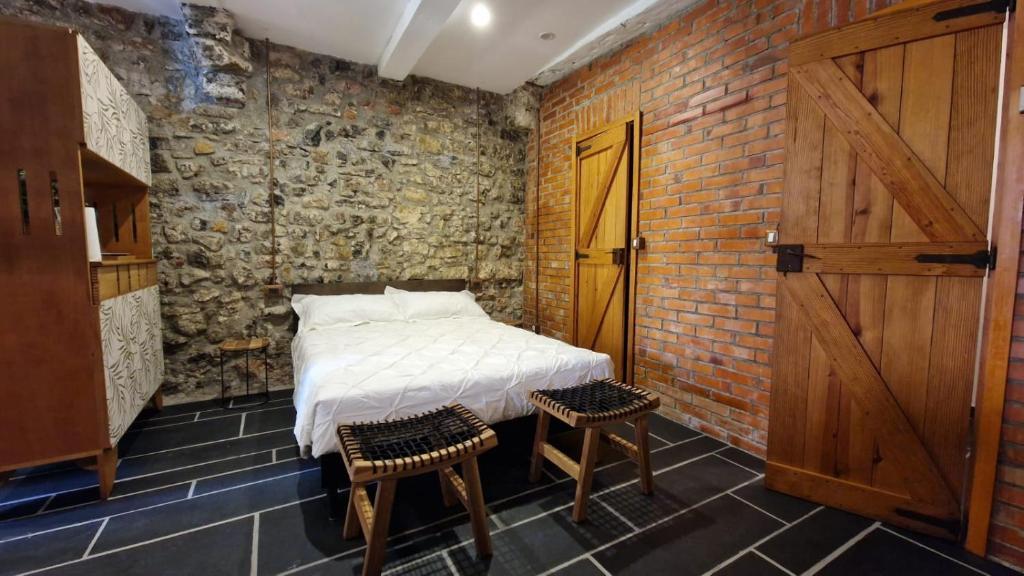 ein Schlafzimmer mit einem Bett in einer Ziegelwand in der Unterkunft Il Rifugio sul Golfo in Tellaro