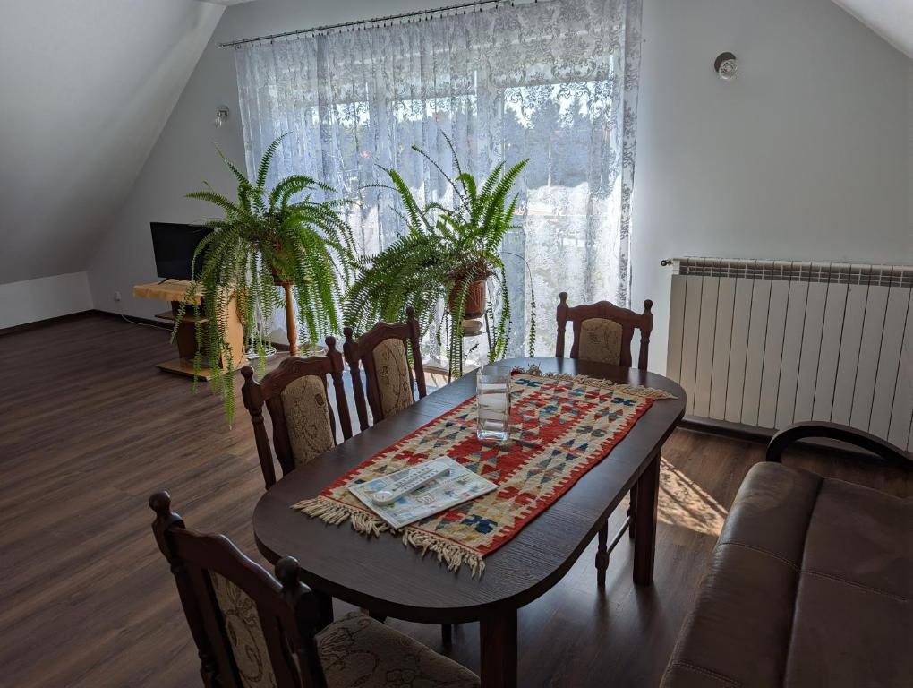 uma sala de jantar com uma mesa e cadeiras e uma janela em Apartament Osak em Stare Juchy