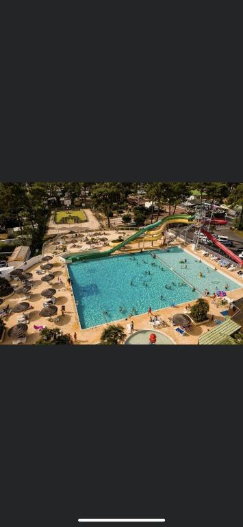 une vue aérienne d'une grande piscine avec des parasols dans l'établissement Mobilhome Luminosa tt équipé 6/8 pers, aux Mathes