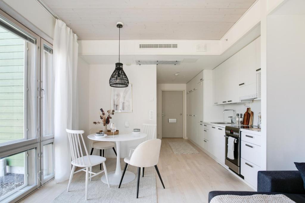 a kitchen with a table and chairs in a room at Woodrise Apartment 