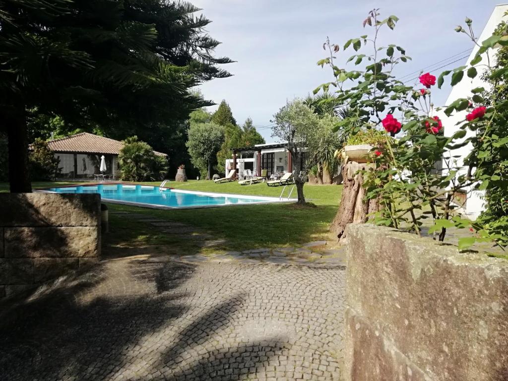 een zwembad in een tuin met een huis bij Casa da Boavista in Santa Maria da Feira