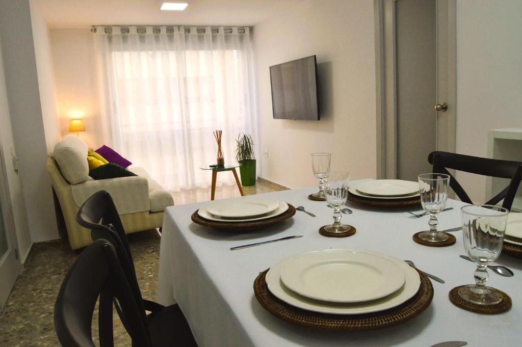 a dining room table with plates and wine glasses at Light in Vila-real, central apartment with office in Villareal