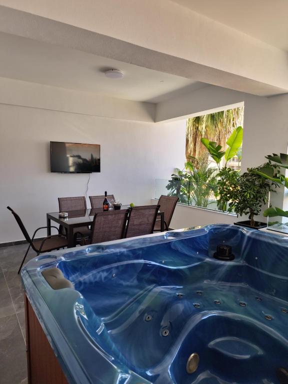 una gran bañera azul en la sala de estar. en Carisa Deluxe Apartment With Jacuzzi, en Lárnaca