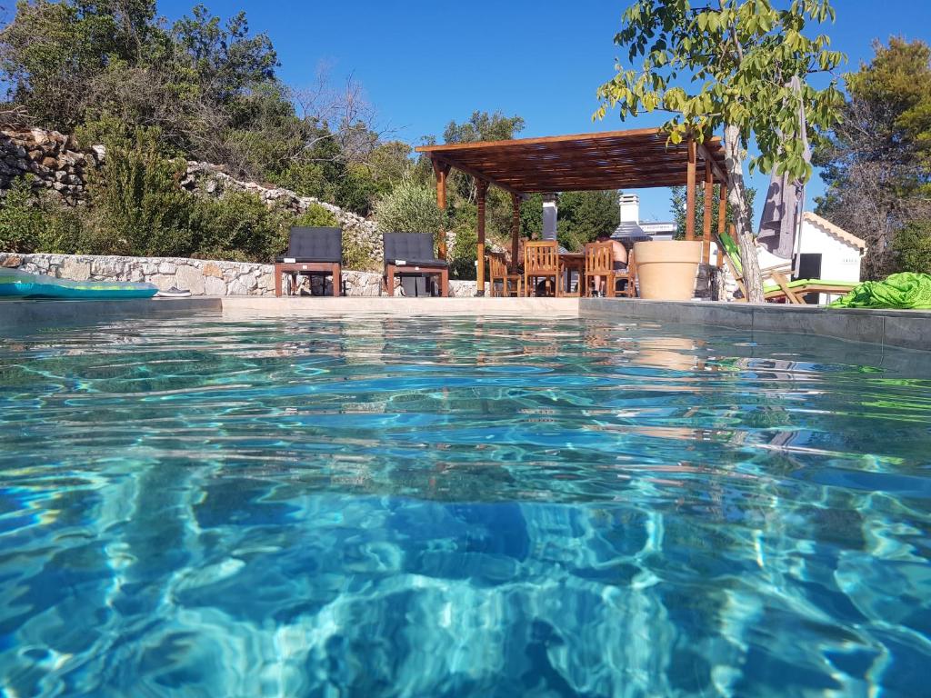 una piscina con cenador y agua azul en Dorinda en Agia Marina