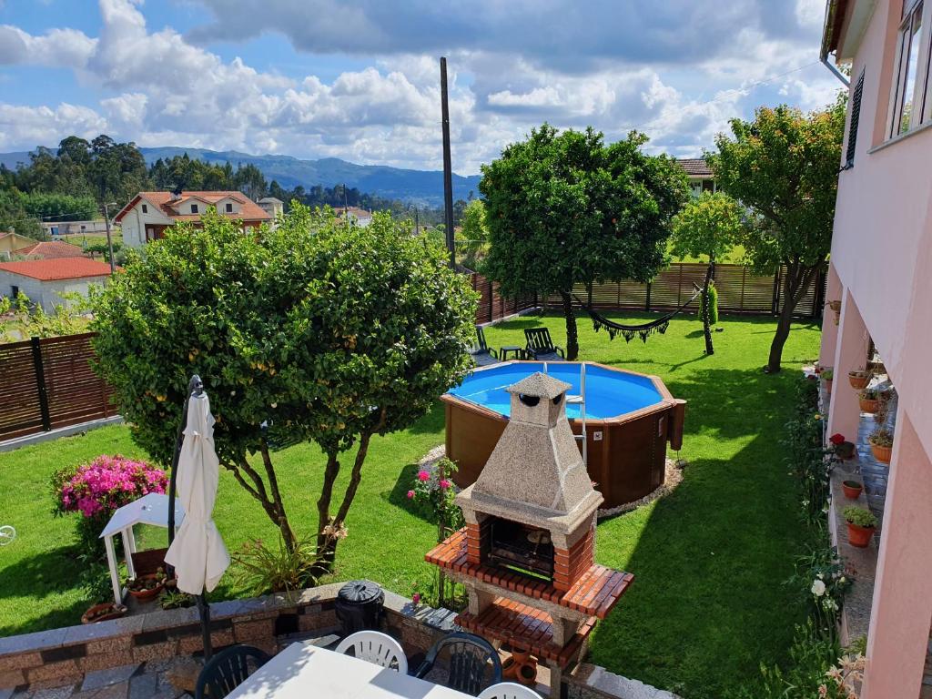 un patio trasero con piscina y chimenea al aire libre en Rosinha Country House en Vale de Cambra
