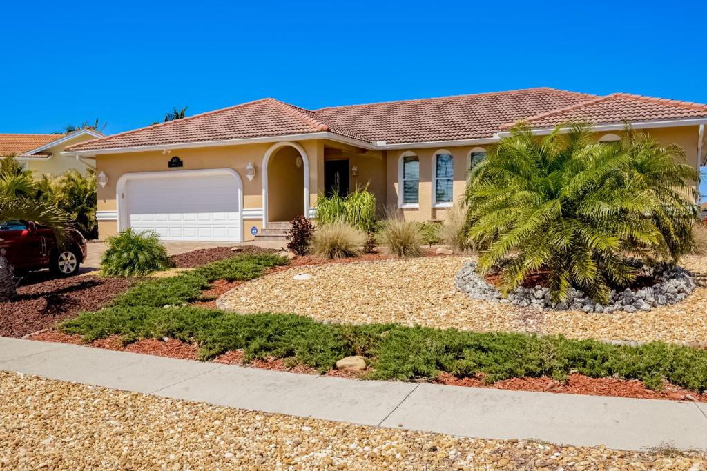 a house with a palm tree in front of it at Marco Beach Escape in Marco Island