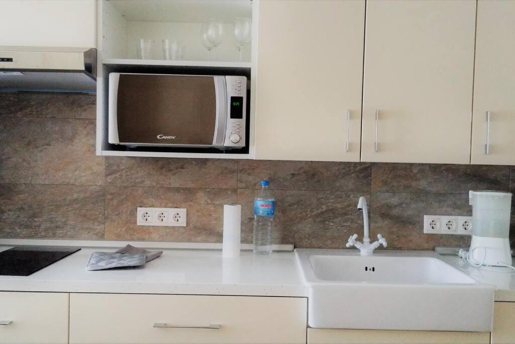 a kitchen with a sink and a microwave at Modern flat at Garbinet with WiFi in Alicante