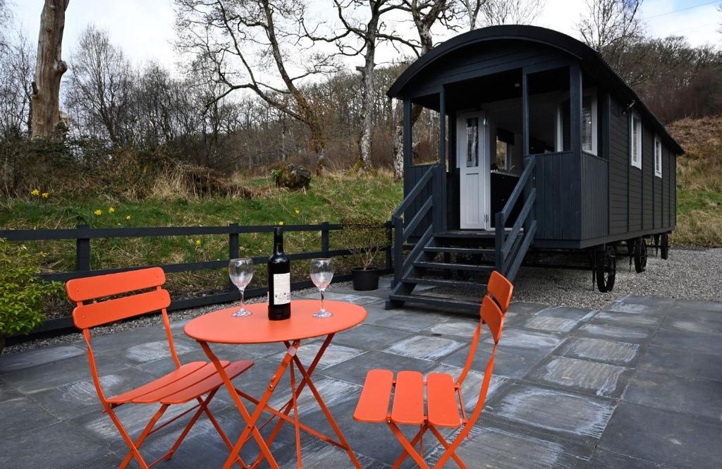 - une table avec deux verres de vin et deux chaises dans l'établissement The Carriage, à Fort William