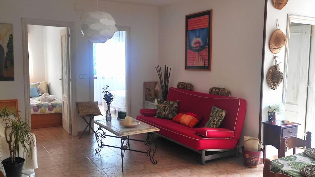 a living room with a red couch and a table at Playa en las Rías Baixas - Raxó in Raxo