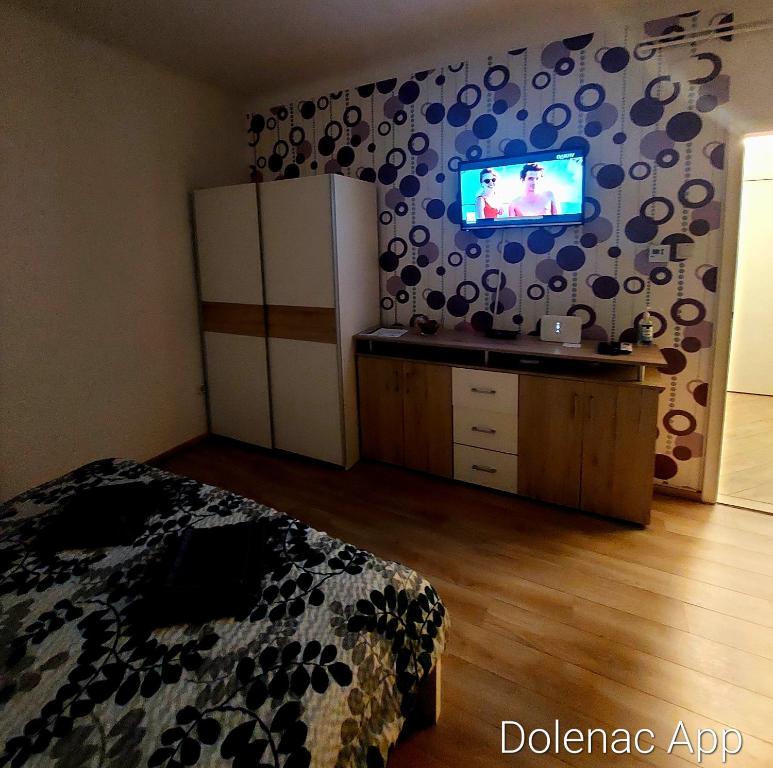 a bedroom with a bed and a tv on a wall at Studio apartman Dolenac in Zagreb