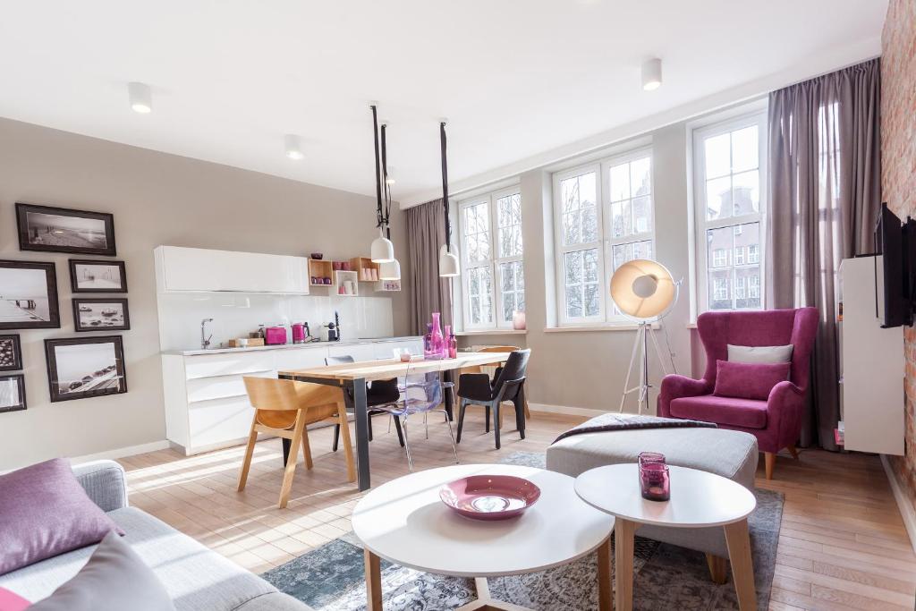 a living room with a couch and tables and chairs at Apartament Soleil III in Gdańsk