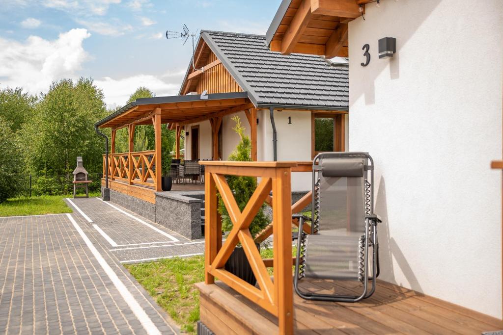 una terrazza in legno con una sedia su una casa di Wielewska Ostoja a Wiele