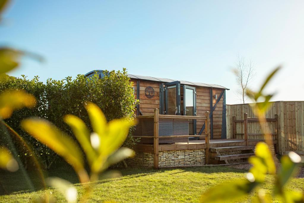 a tiny house on a deck in a yard at Yew Lodge - Shepherd's Hut Railway Carriage with "Hot Tub" - Sleeps 4 - Escape Completely! in Boston