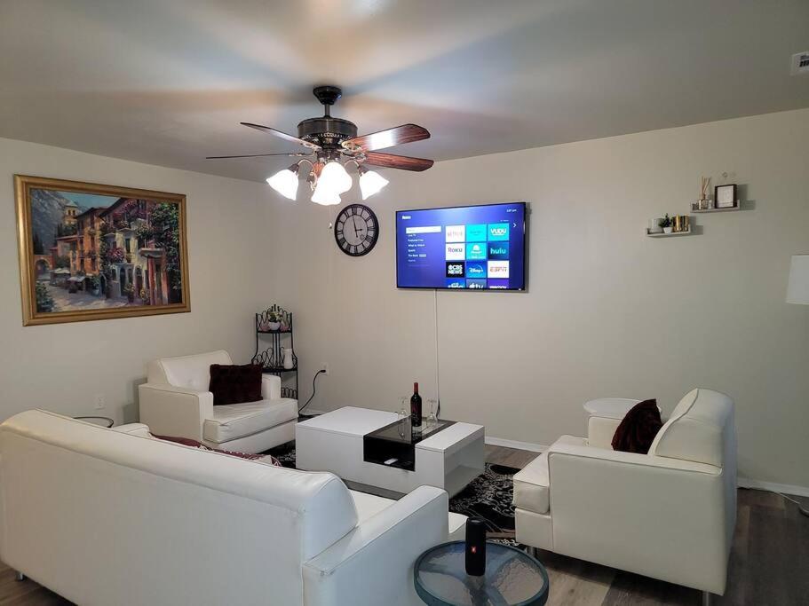 a living room with white furniture and a ceiling fan at Lovely welcoming 3 bedroom house 