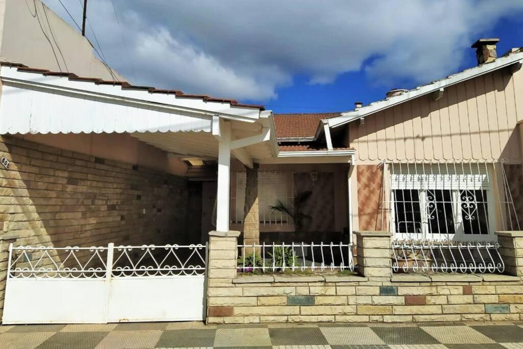 a house with a white fence in front of it at Casa Mercedes in Mercedes