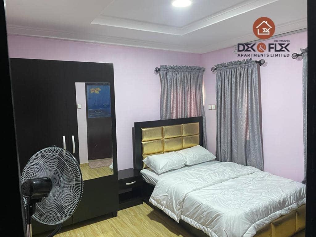 a bedroom with a bed and a fan at Dex & Flex Apartments in Ibadan