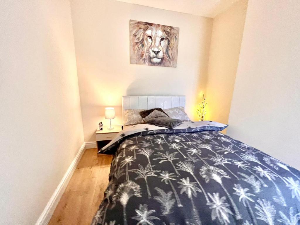 a bedroom with a bed with a lion picture on the wall at Relax dotcom in Manchester