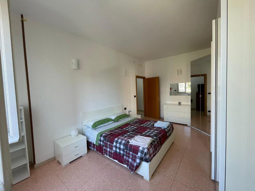 1 dormitorio con 1 cama con manta a cuadros en Splendido appartamento in zona fiera a bologna en Bolonia