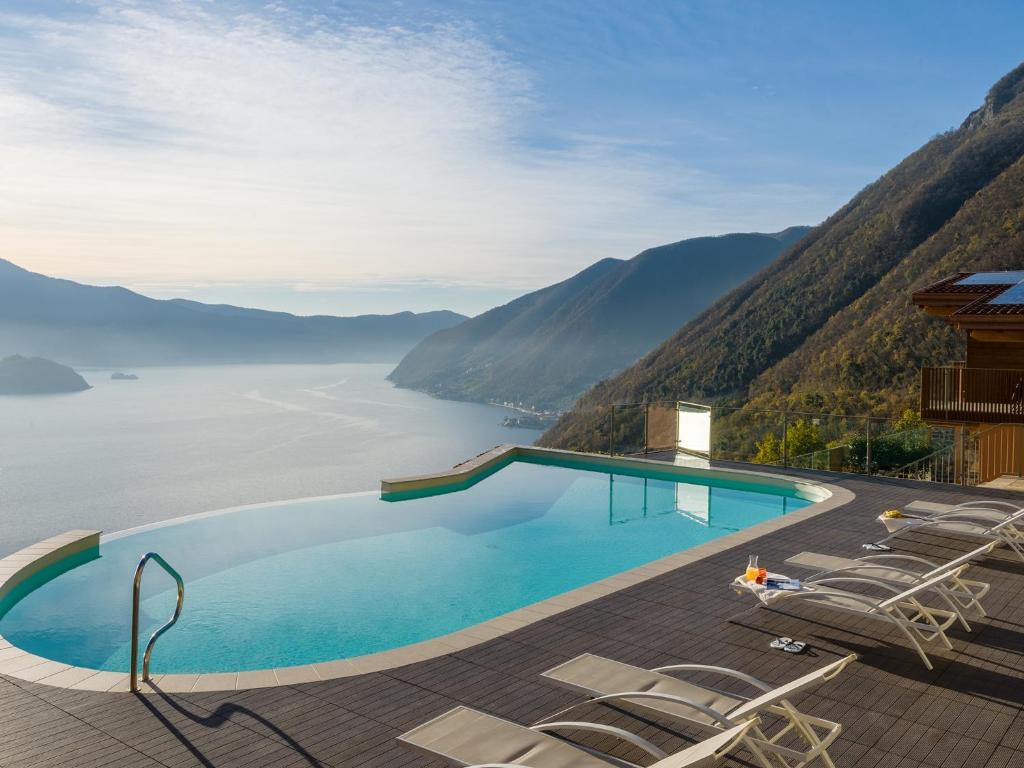 a swimming pool with chairs and a view of the water at Segesta - with panoramic outdoor area and swimming pool in Parzanica