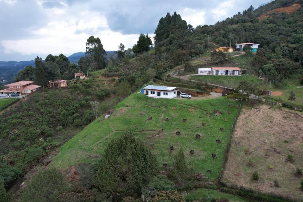 an aerial view of a house on a hill with animals at El Mirador de LucyMelia in Guarne