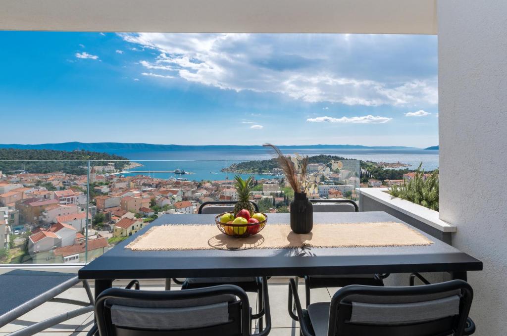 a table with a bowl of fruit on a balcony at Luxury Apartment LA MAR Sea&City view in Makarska