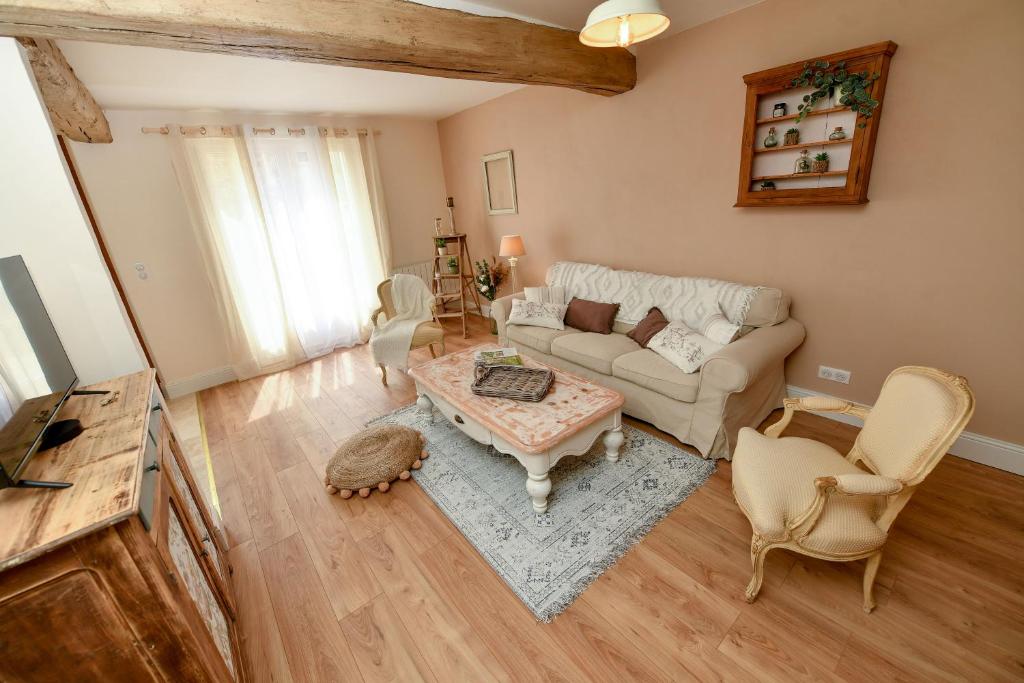 a living room with a couch and a table at Le clos des voisins in Verneuil