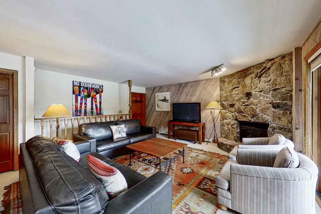 uma sala de estar com mobiliário de couro e uma parede de pedra em Phoenix 209 em Steamboat Springs