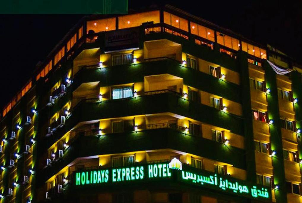 un edificio con luces verdes en el lateral. en Holidays Express Hotel, en El Cairo