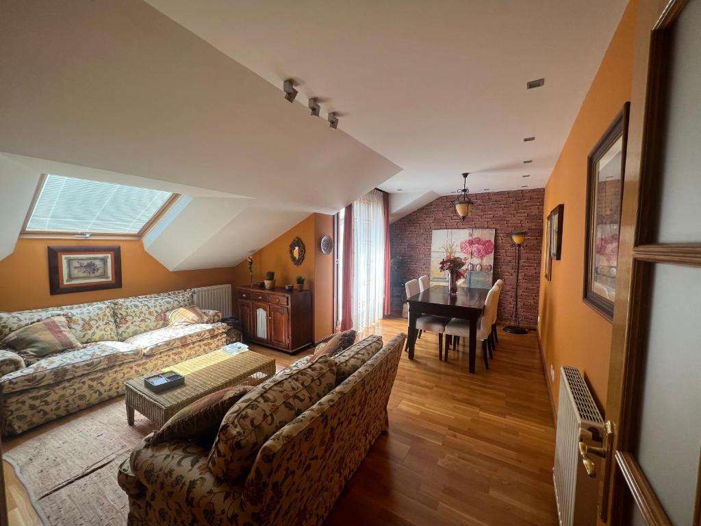 a living room with a couch and a table at Atractivo Ático 2 Habitaciones in Villaviciosa