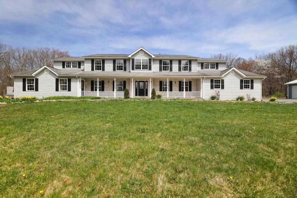a large white house with a large grass field at Luxe Lrg Pocono House for 18 Hot Tub/Gameroom/Pool in Kunkletown