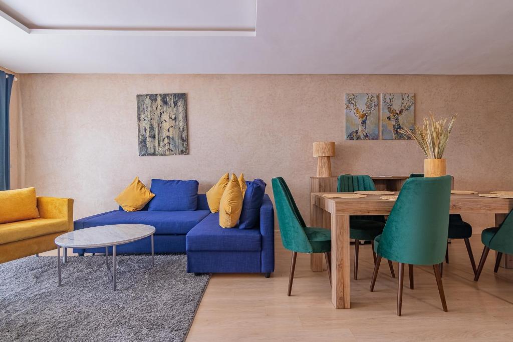 sala de estar con sofá azul y mesa en Appartement moderne central Prestigia, en Marrakech