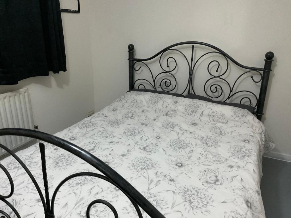 a bed with a white bedspread with flowers on it at Comfy Double Room In Our Shared House in Palmers Green