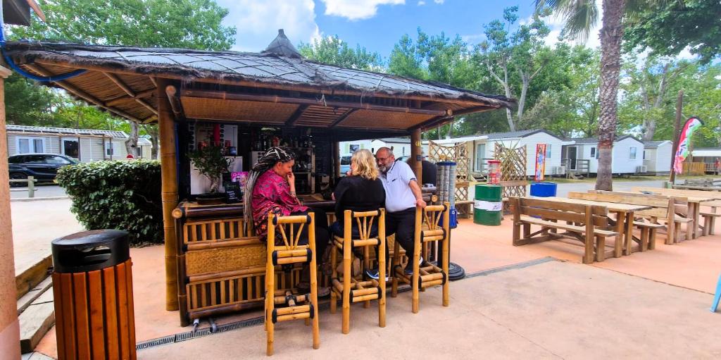 un groupe de personnes assises au bar dans un kiosque dans l'établissement Tribord Dix Neuf, au Grau-du-Roi