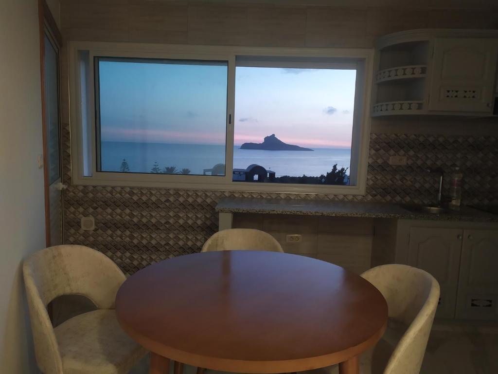 a table and chairs in a kitchen with a window at Galia in Rafrāf