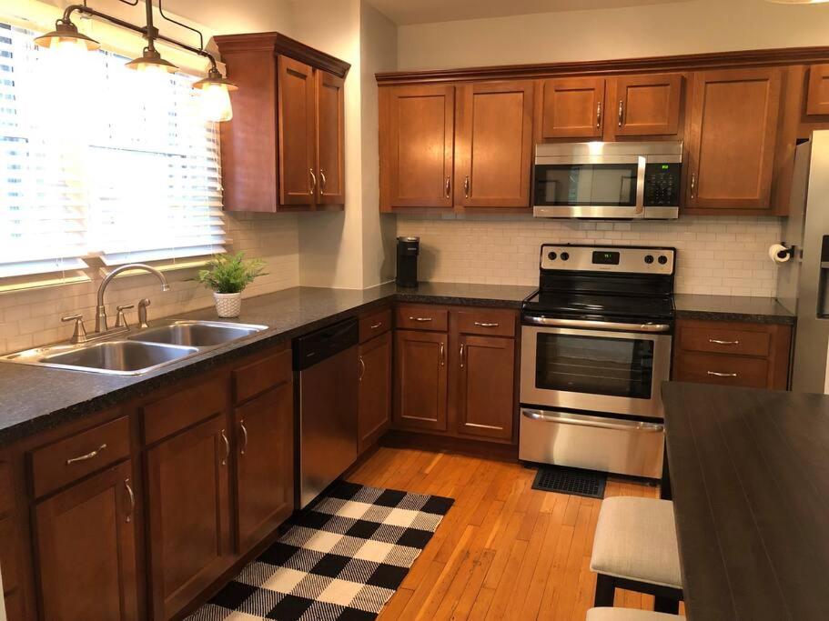 a kitchen with wooden cabinets and stainless steel appliances at Close to Earlham, Reid, IU in Richmond
