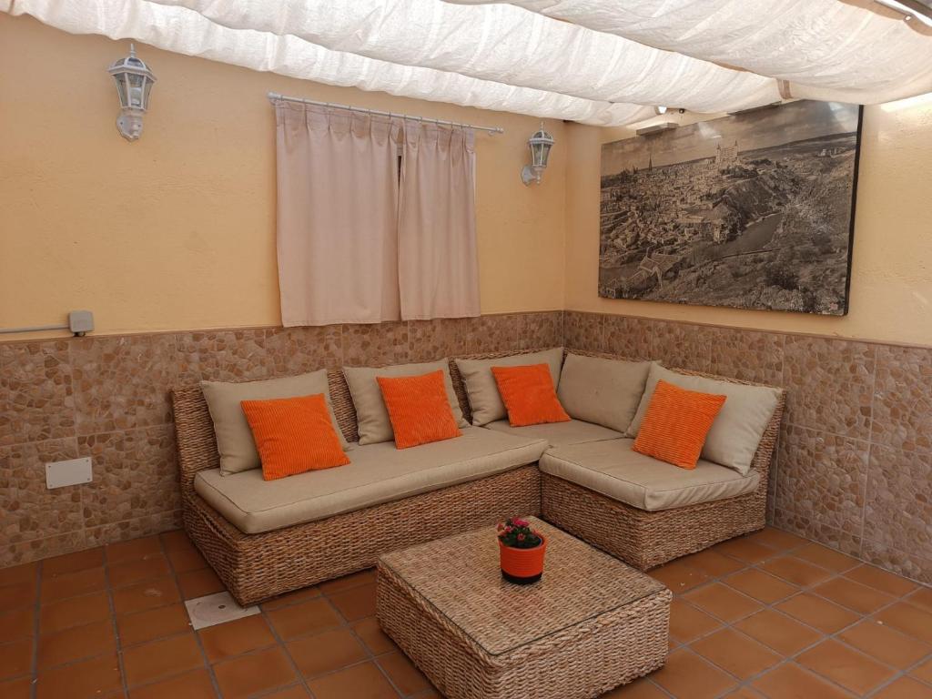 a living room with a couch and orange pillows at La Casa de los Patos in Toledo