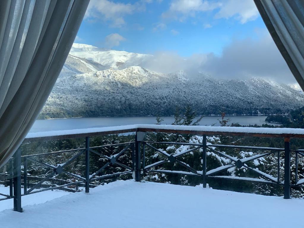 a view of snow covered mountains from a balcony at Estancia Del Carmen Mountain Resort in San Carlos de Bariloche