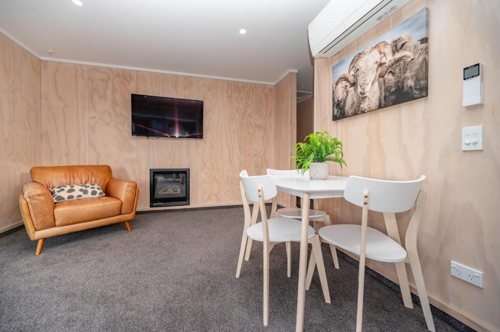 a living room with a table and chairs and a couch at Starbright Townhouse in Twizel