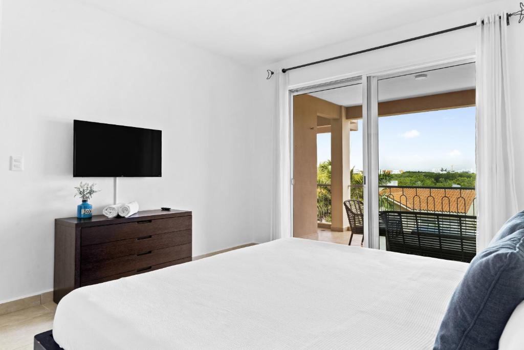 um quarto com uma cama, uma televisão e uma varanda em 4 BR apartment, 8 guests em Cancún