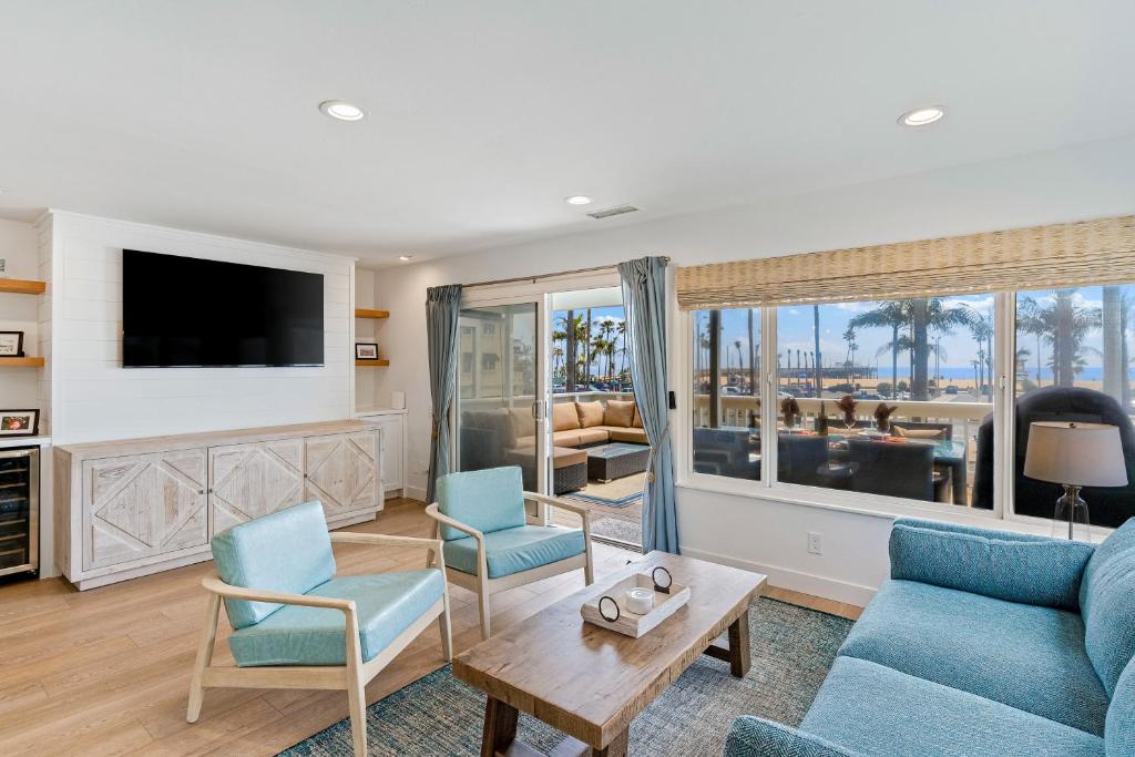 ein Wohnzimmer mit einem Sofa, Stühlen und einem TV in der Unterkunft Balboa Beauty in Newport Beach