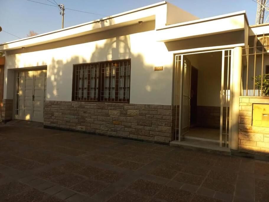 Casa blanca con una gran puerta de cristal en Amplia casa para 6 huéspedes en Mendoza en Godoy Cruz