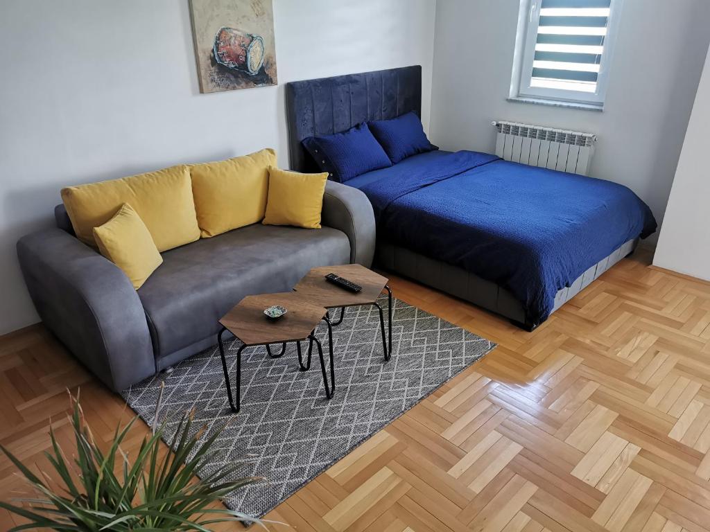 een woonkamer met een bank en een bed bij DJS-Modern Studios in Skopje