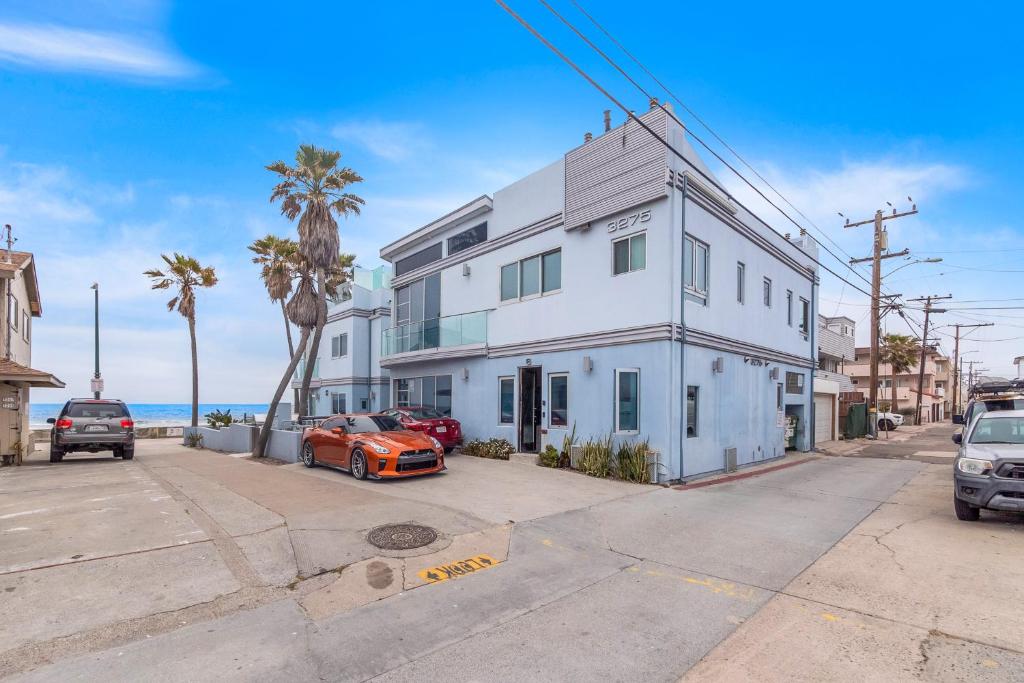 a white building with two cars parked in front of it at Beach Baller Bungalow in San Diego