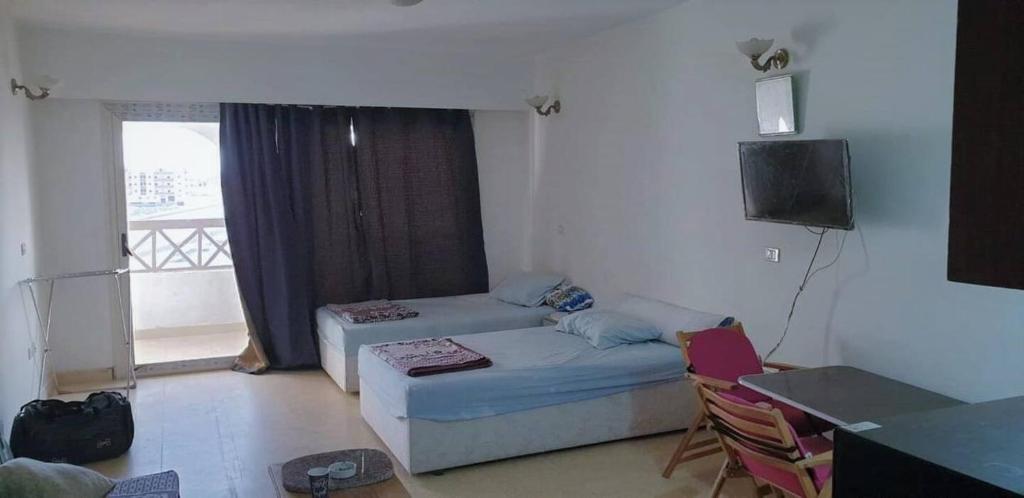 uma sala de estar com um sofá, uma mesa e uma televisão em Palma Resort em Hurghada