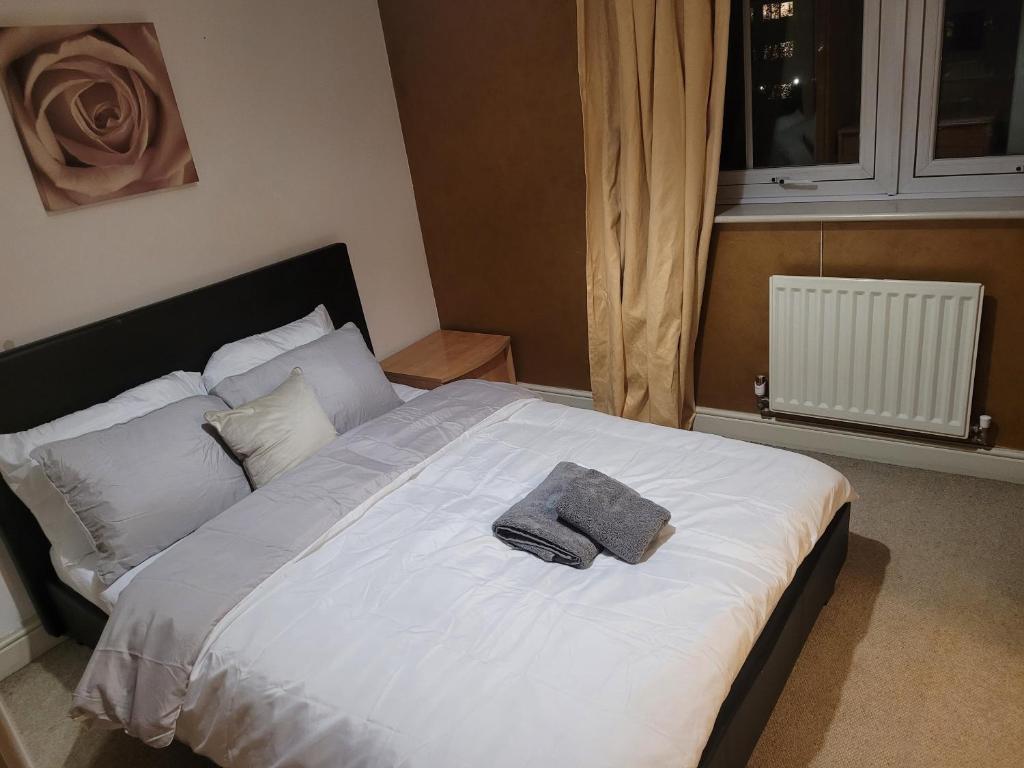 a bedroom with a white bed with a towel on it at OneFourSeven Place in Manchester