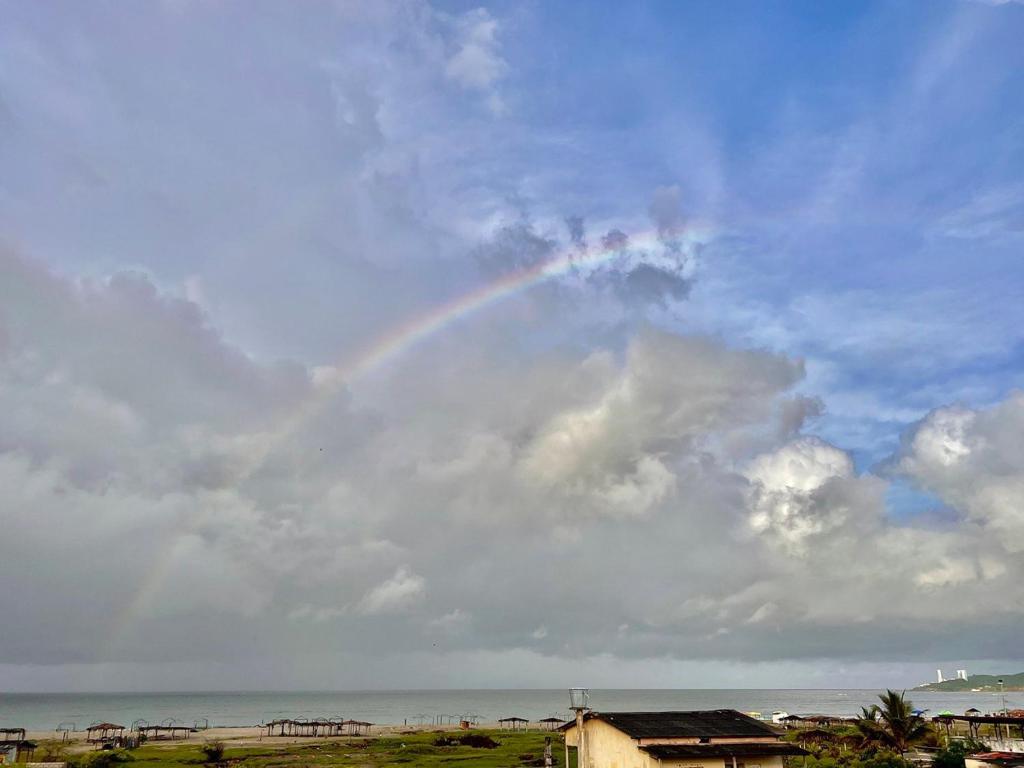 een regenboog in een bewolkte hemel boven de oceaan bij Apartamento Violeta con Impresionante Vista al Mar in Playas