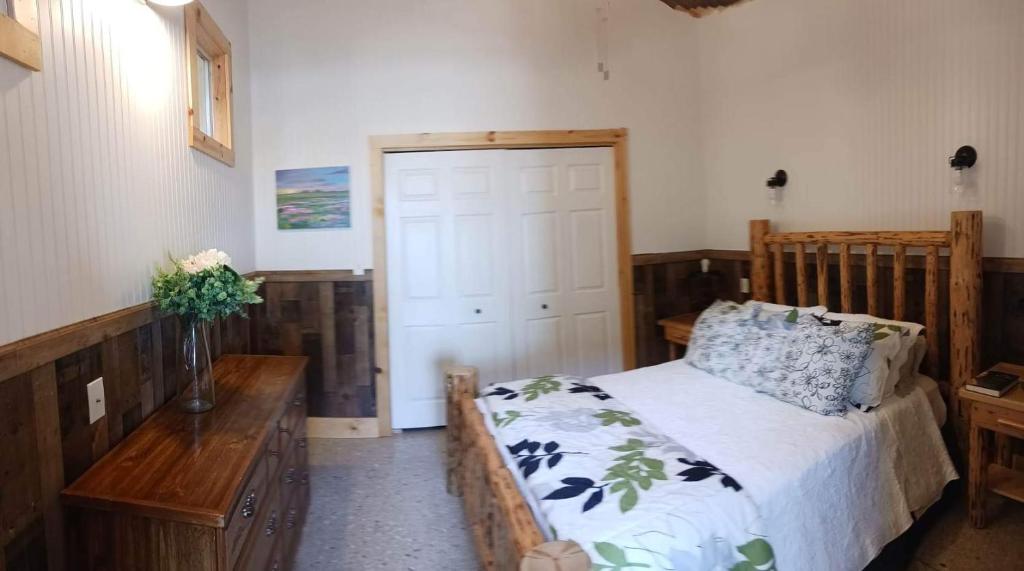 1 dormitorio con cama de madera y mesa de madera en Whitetail Meadows Ranch, en Johnson City